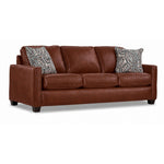 City Leather Sofa - Brown in a three-quarter view with three seat cushions, slim track arms, dark wood legs and two patterned accent pillows