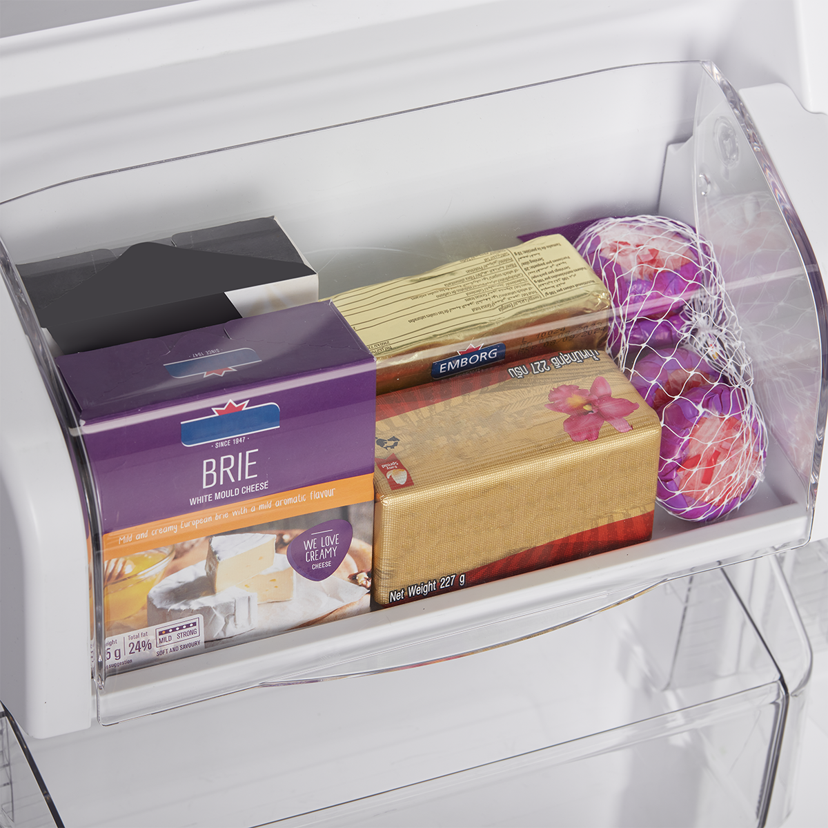 Covered refrigerator door bin holding cheese and packaged foods