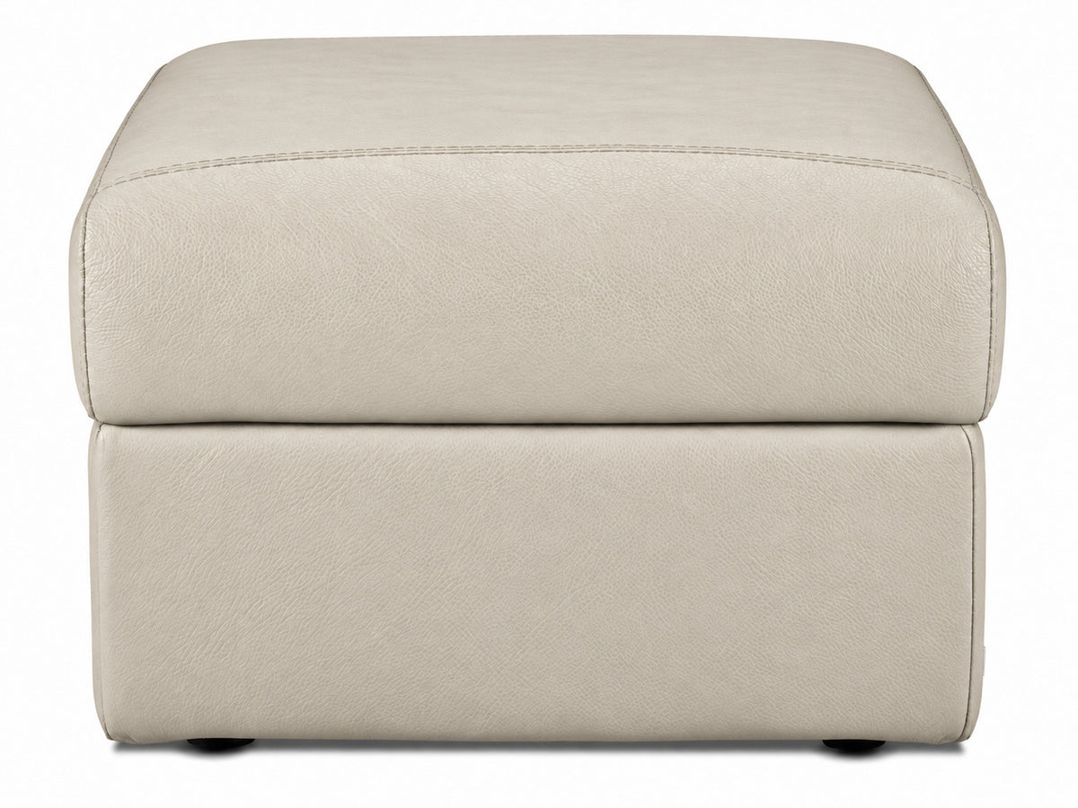 Front view of the cream leather ottoman with rounded padded top and low-profile feet