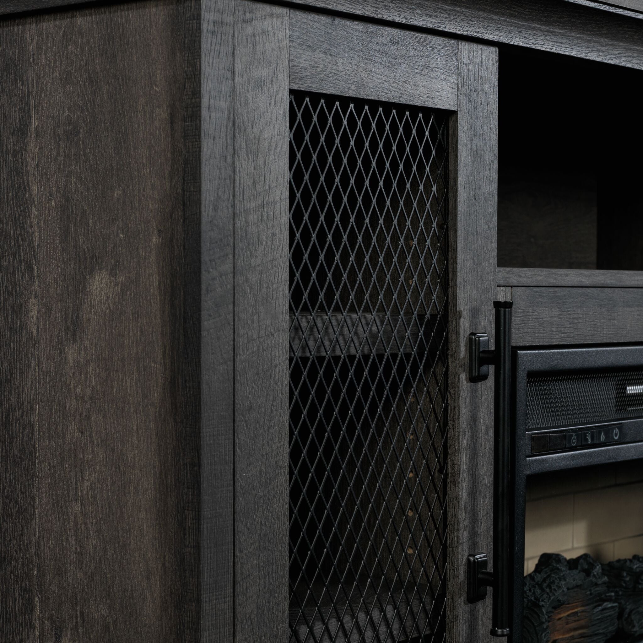 Close-up of Millbrook Fireplace TV Stand showing Fawn Aged Oak finish, black diamond mesh cabinet door and metal handle