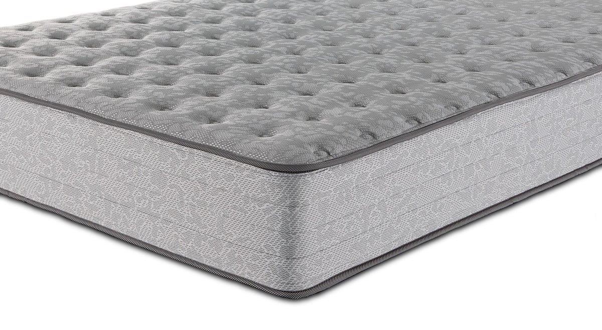 Close-up of Sealy Burchelle Extra Firm Tight Top Queen mattress showing tufted surface, piping and patterned side panel