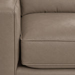 Close-up of the City Leather Sofa - Stone showing the leather grain, piped seat cushion and matching upholstered arm