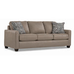 City Leather Sofa - Stone in a three-quarter view with three seat cushions, slim track arms, dark wood legs and two patterned accent pillows