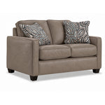 City Leather Loveseat - Stone in a three-quarter view with two cushioned seats, slim track arms, dark wood legs and two patterned accent pillows