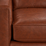 Close-up of the City Leather Sofa - Brown showing the leather grain, piped seat cushion and matching upholstered arm