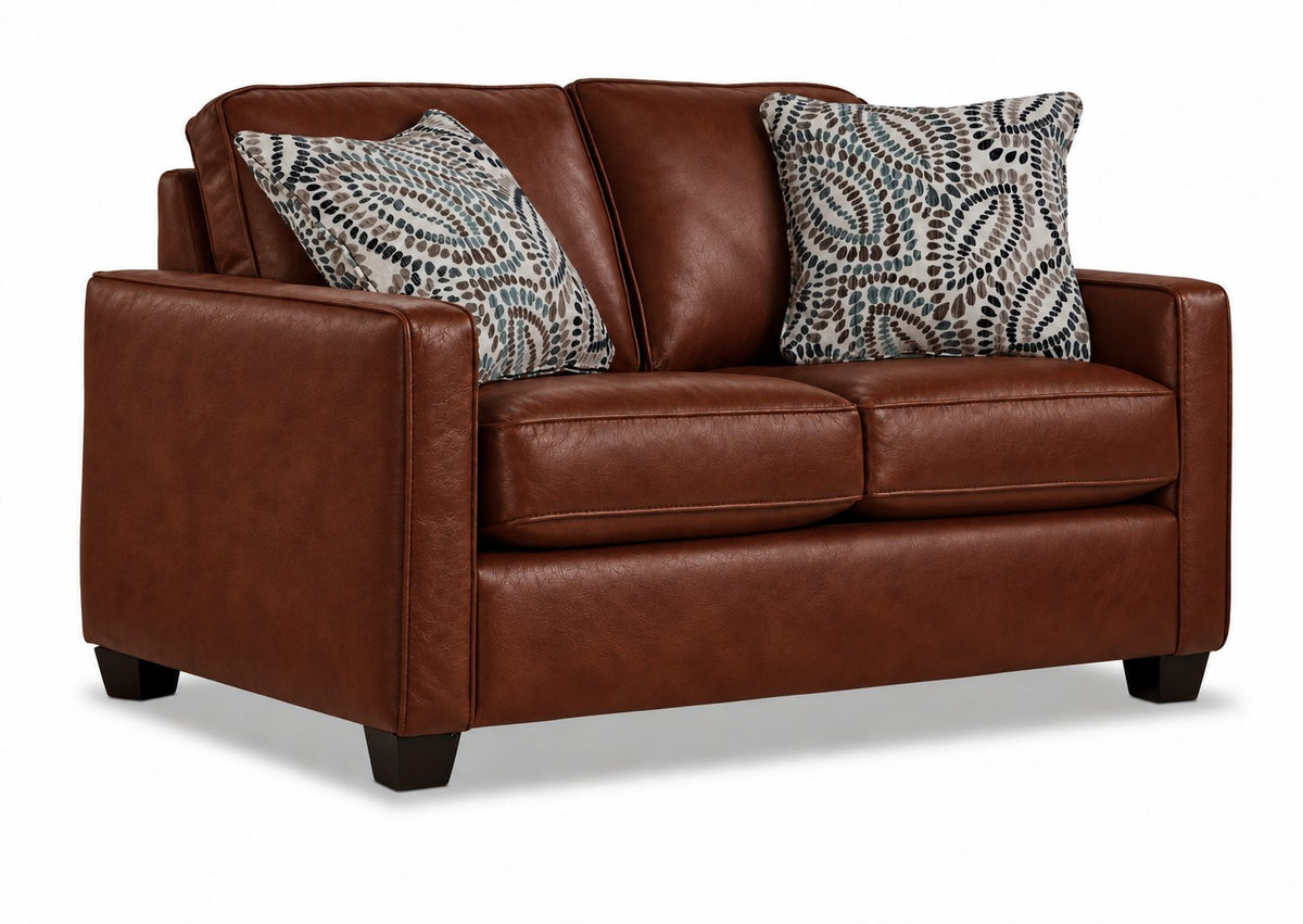 City Leather Sofa - Brown in a three-quarter view with three seat cushions, patterned accent pillows and dark wood legs