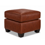 City Leather Ottoman - Brown in a three-quarter view with a thick piped cushion, leather upholstery and dark wood legs