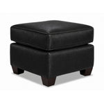 City Leather Ottoman - Black in a three-quarter view with a thick piped cushion, leather upholstery and dark wood legs