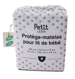 Petit Léon crib mattress protector in white polka-dot drawstring packaging with 28 x 52 x 9 inch sizing