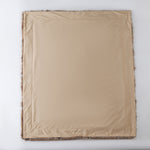 The Great Indoors 50 x 60" faux fur throw laid flat, showing the smooth beige reverse side.